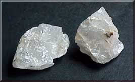 Clear quartz crystals resting on pale rock.
